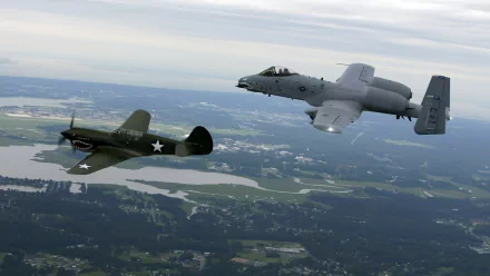 A Fairchild Republic A-10 Thunderbolt II flies alongside an F4U Corsair in a dramatic aerial scene, showcasing iconic military aircraft in flight against a scenic backdrop.