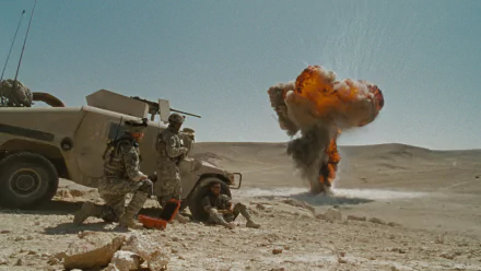 HD PC desktop wallpaper from The Hurt Locker: soldiers beside a Humvee in a desert watching a distant mushroom-cloud explosion.