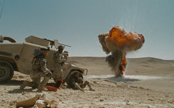 HD PC desktop wallpaper from The Hurt Locker: soldiers beside a Humvee in a desert watching a distant mushroom-cloud explosion.