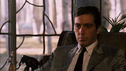 HD PC desktop wallpaper featuring a serious Michael Corleone from The Godfather and The Godfather: Part II, set in a dimly lit room with a window in the background.