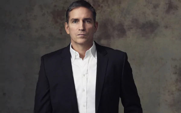 John Reese, portrayed by Jim Caviezel in the TV show Person of Interest, stands in a sharp suit against a textured backdrop in this 8K Ultra HD desktop wallpaper.