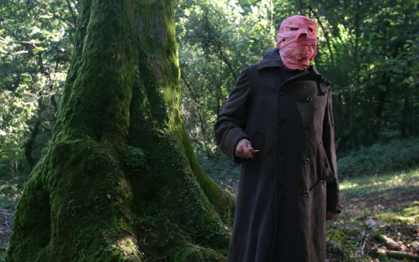 Timecrimes movie 2K Quad HD PC desktop wallpaper and background: masked man in a dark coat holding a knife in a mossy forest clearing.