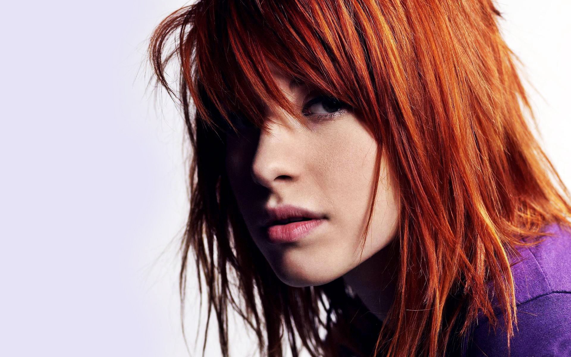 HD PC desktop wallpaper featuring a close-up portrait of Hayley Williams with vibrant red hair, capturing her expressive gaze in a music-themed image.