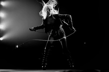 Black-and-white 4K Ultra HD wallpaper of Taylor Momsen performing energetically on stage with dramatic lighting, capturing the raw intensity of her music.
