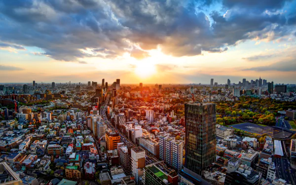 A stunning 4K Ultra HD view of Tokyo, Japan, showcasing a vibrant cityscape with skyscrapers under a dramatic sunset. Man-made structures contrast beautifully with the sky.