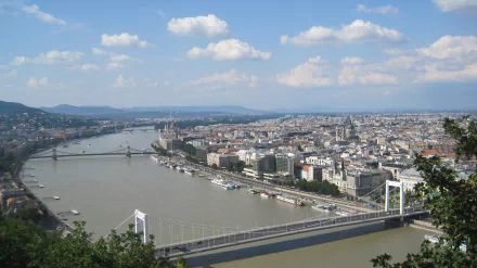 Panoramic view of Budapest, Hungary, featuring the Danube and man-made bridges sweeping past the city skyline — 2K Quad HD PC desktop wallpaper/background