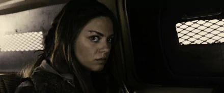 HD PC desktop wallpaper featuring Mila Kunis in a scene from the movie The Book of Eli, showcasing a dark, intense atmosphere.