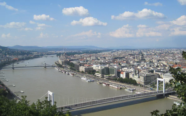 Panoramic view of Budapest, Hungary, featuring the Danube and man-made bridges sweeping past the city skyline — 2K Quad HD PC desktop wallpaper/background