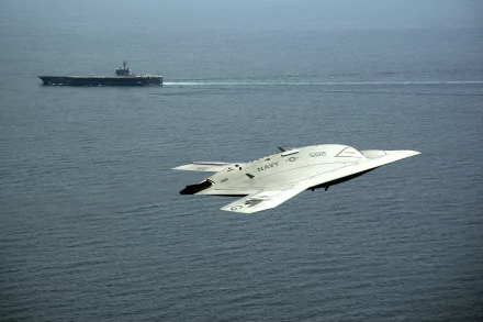 4K desktop wallpaper: Northrop Grumman X-47B unmanned jet flying over sea with USS George H.W. Bush (CVN-77) carrier in background, military naval aviation scene.