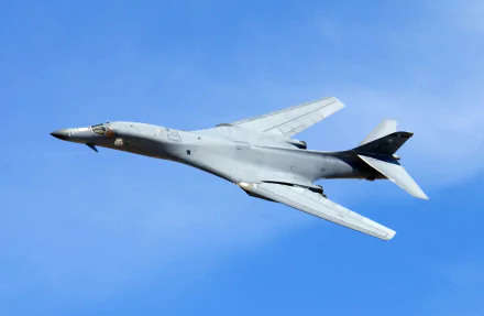 Rockwell B-1 Lancer military bomber soaring against a clear blue sky, captured in crisp detail for an HD PC desktop wallpaper background.