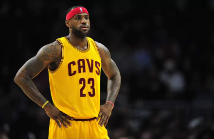 LeBron James stands on the court in a Cleveland Cavaliers uniform, showcasing his focus and determination in this vibrant 4K Ultra HD sports wallpaper.