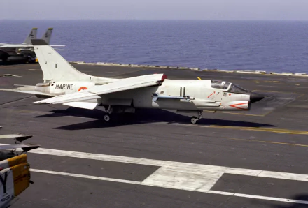 HD desktop wallpaper featuring a military Vought F-8 Crusader jet preparing for takeoff from an aircraft carrier at sea.