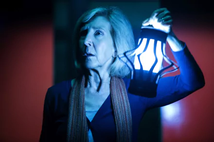Lin Shaye from Insidious: Chapter 3 holding a glowing lantern in a dark, eerie setting, captured in a 4K Ultra HD PC desktop wallpaper and background.