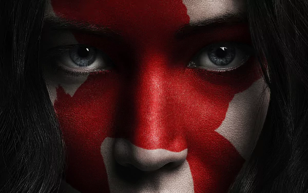 Close-up of Jennifer Lawrence with a red and white face paint design from The Hunger Games: Mockingjay - Part 2, presented as a 4K Ultra HD PC desktop wallpaper.