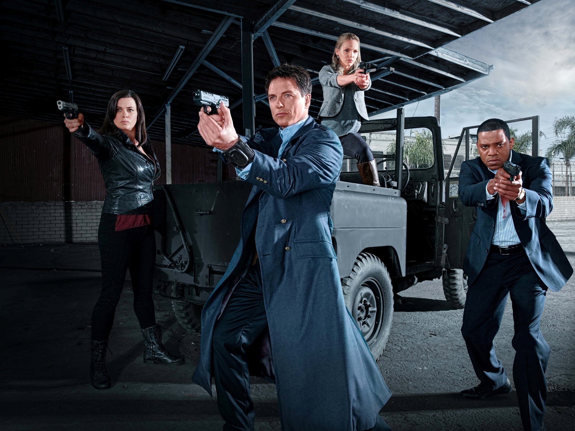 Torchwood TV show team aiming guns beside a military jeep in a moody night scene — 5K Ultra HD PC desktop wallpaper/background.