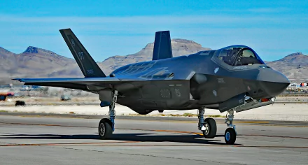 Lockheed Martin F-35 Lightning II jet on a runway with mountains in the background, captured in high definition for a military-themed PC desktop wallpaper.