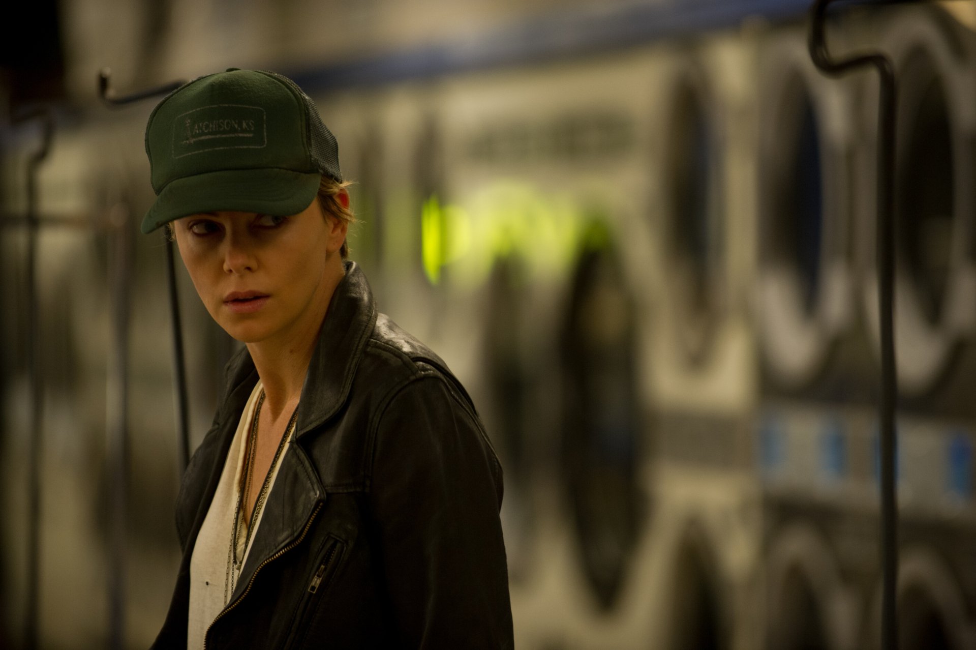 Charlize Theron in a dimly lit laundromat scene from the movie Dark Places, presented as a 4K Ultra HD PC desktop wallpaper and background.
