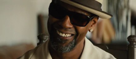 HD desktop wallpaper featuring Denzel Washington as Robert 'Bobby' Trench from the movie 2 Guns, wearing sunglasses and a hat with a confident smile.