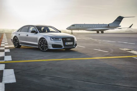 A silver Audi S8 parked on an airport runway with a private jet in the background, captured in 4K Ultra HD for a sleek PC desktop wallpaper.