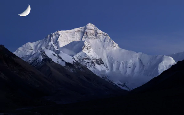 Snow-covered mountain under a crescent moon at dusk, capturing serene natural beauty in this HD desktop wallpaper and background.