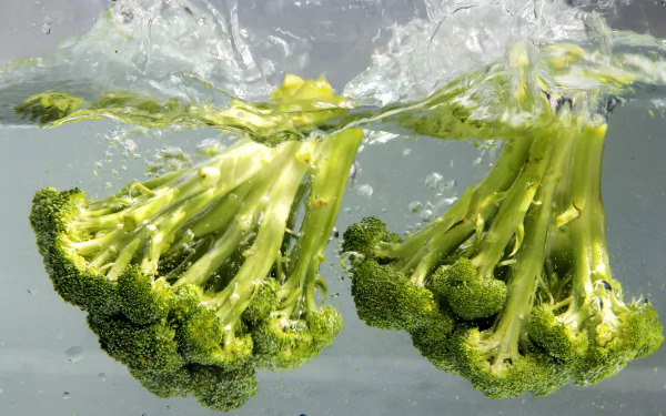 4K Ultra HD PC desktop wallpaper: fresh broccoli florets splashing in water, vibrant food photography background