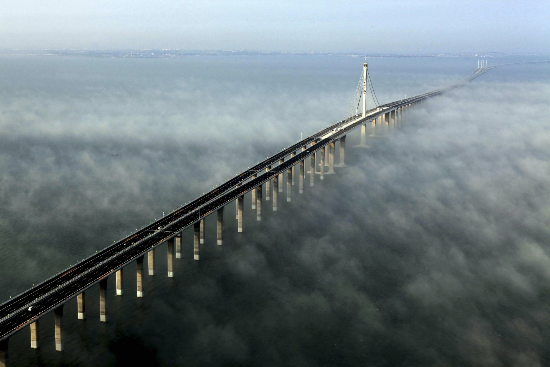 Aerial 5K Ultra HD PC desktop wallpaper and background of the man-made Jiaozhou Bay Bridge stretching through morning mist.