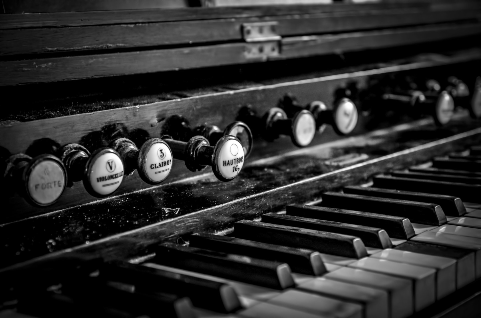 Black and white close-up of a vintage piano keyboard and stops, captured in sharp detail as a 4K Ultra HD desktop wallpaper showcasing musical elegance.
