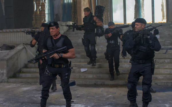 4K PC wallpaper of The Expendables 3: a mercenary squad in tactical gear advancing through a ruined building, guns raised in a gritty cinematic action scene.