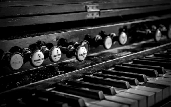 Black and white close-up of a vintage piano keyboard and stops, captured in sharp detail as a 4K Ultra HD desktop wallpaper showcasing musical elegance.