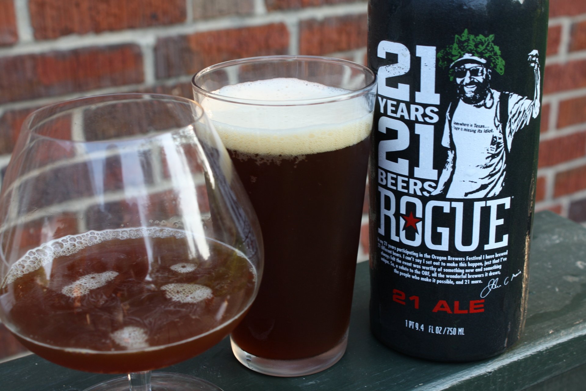 Food, beer 4K Ultra HD PC desktop wallpaper background: Rogue 21 Ale bottle with a pint and a snifter of dark ale on a green railing against a brick wall.