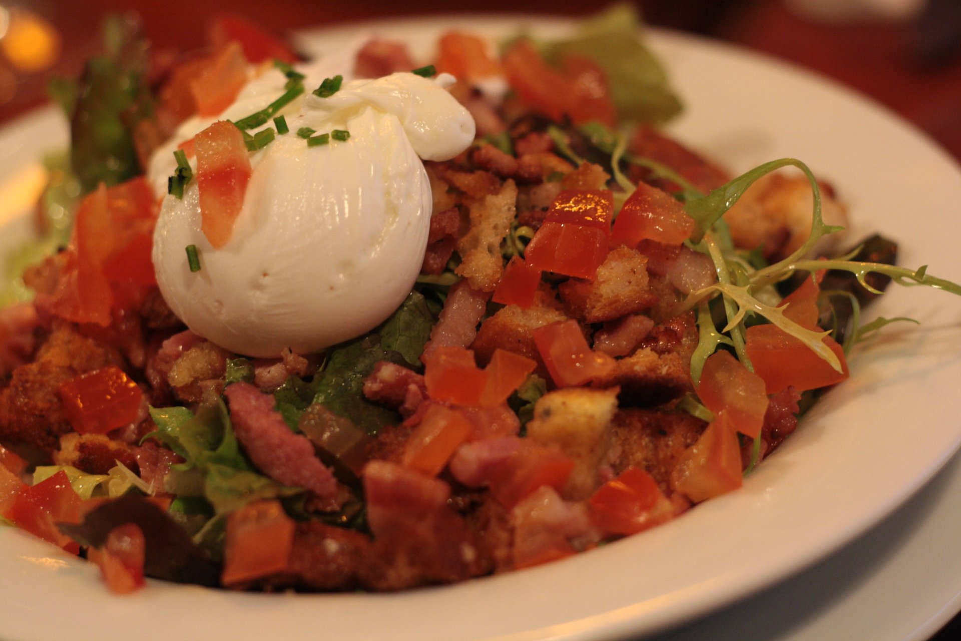 4K Ultra HD PC desktop wallpaper of a Salade Lyonnaise meal: mixed greens with croutons, crispy bacon, diced tomatoes and a soft poached egg on top.