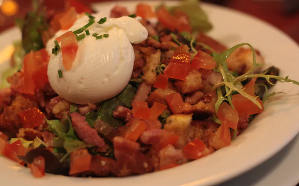 4K Ultra HD PC desktop wallpaper of a Salade Lyonnaise meal: mixed greens with croutons, crispy bacon, diced tomatoes and a soft poached egg on top.