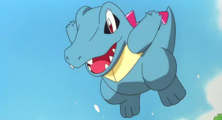 A vibrant HD wallpaper featuring Totodile, the playful water-type Pokémon, depicted in an anime style, joyfully leaping against a blue background.