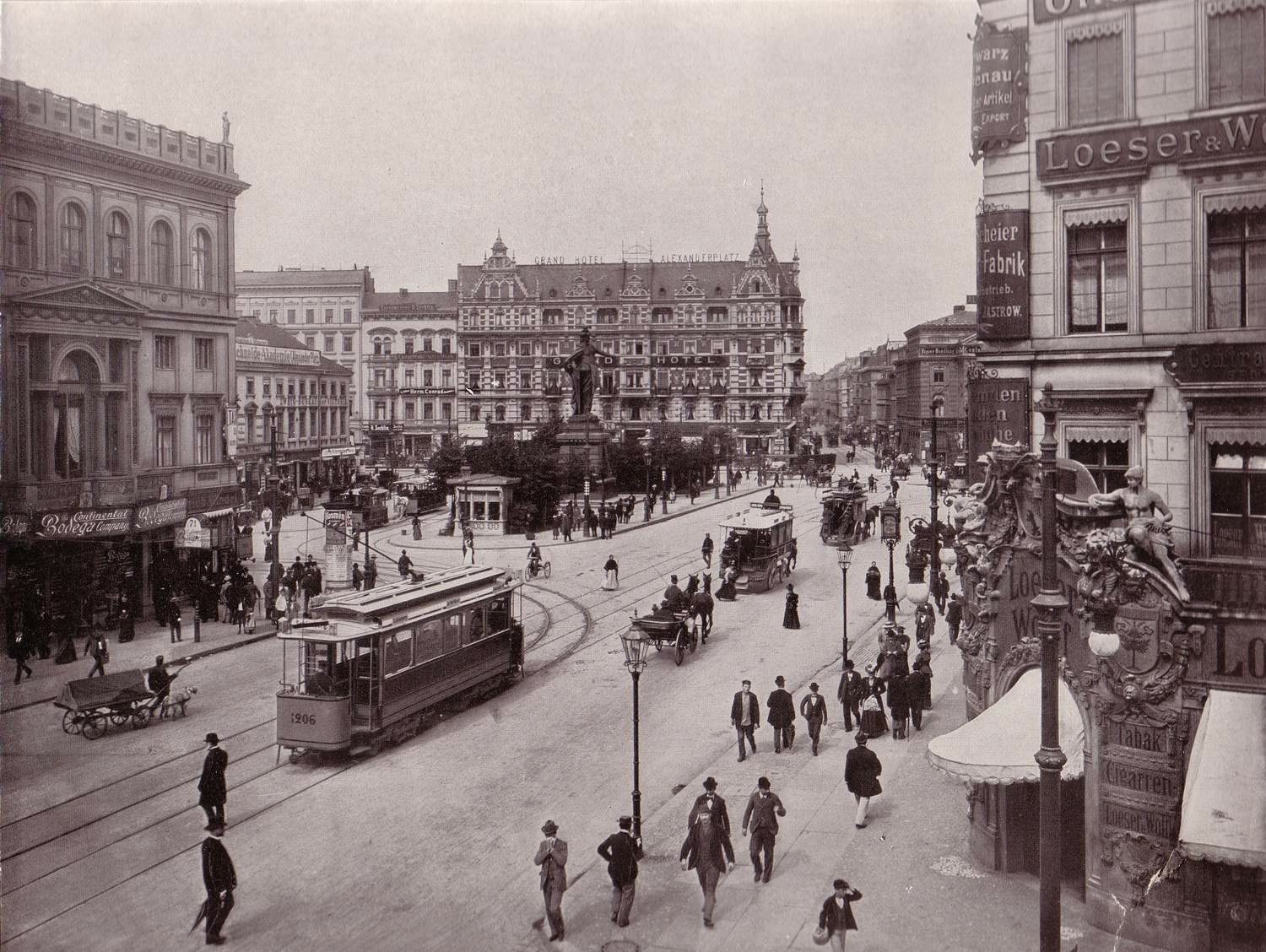 Black-and-white photograph of historic Berlin, Germany: trams, horse-drawn carriages and pedestrians passing ornate buildings — HD PC desktop wallpaper/background.