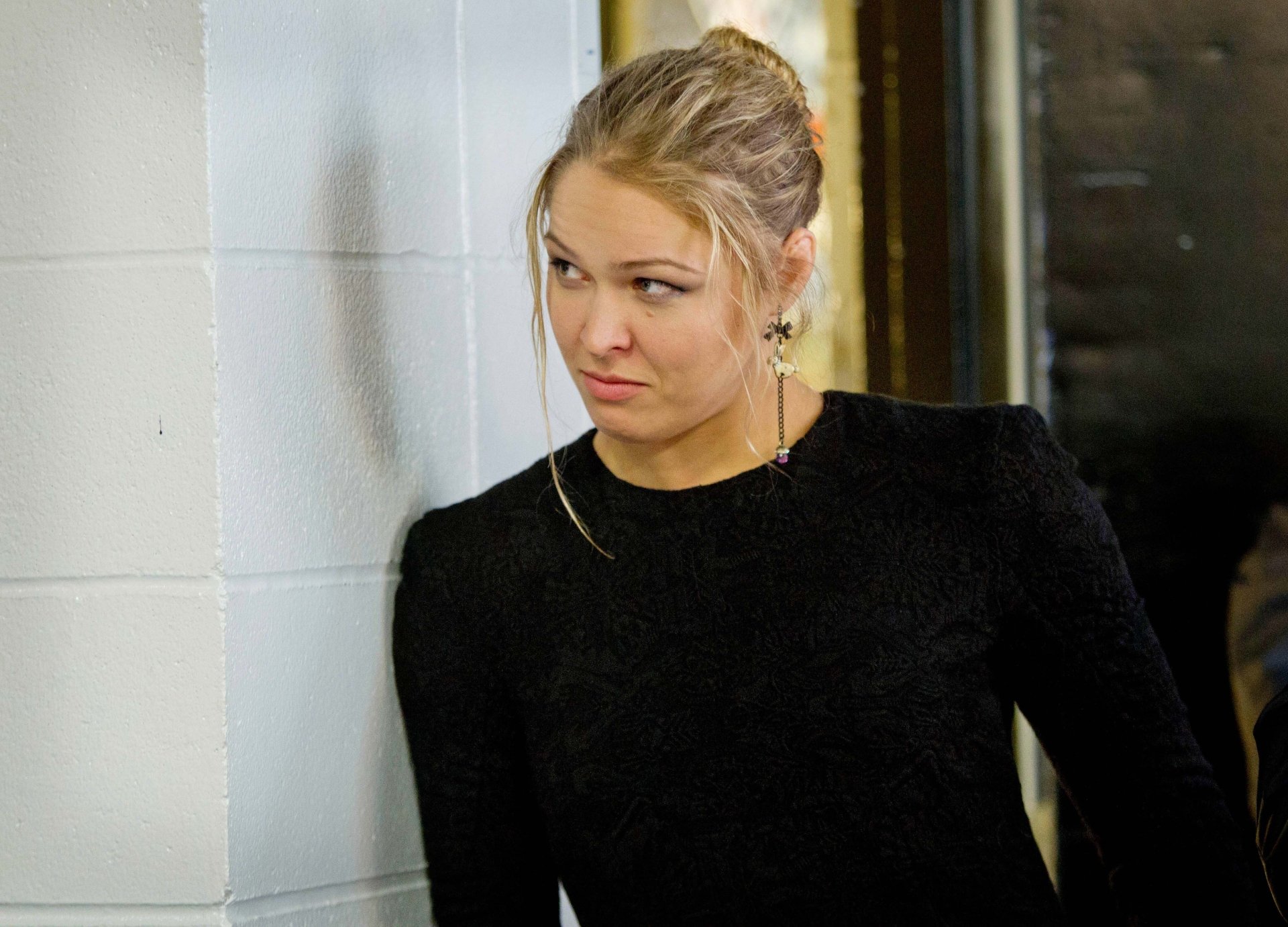 A high-definition desktop wallpaper featuring Ronda Rousey, showcasing her intense expression against a simple background, embodying the spirit of sports and determination.
