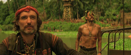 A captivating HD wallpaper from *Apocalypse Now*, featuring two characters in a lush, jungle setting, evoking the film's intense atmosphere and themes of conflict and survival.