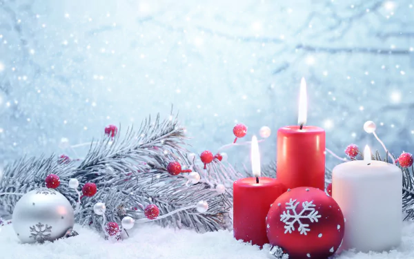 A serene winter scene featuring red and white candles surrounded by festive Christmas ornaments, with a snowy background and gentle snowfall, creating a cozy holiday atmosphere.
