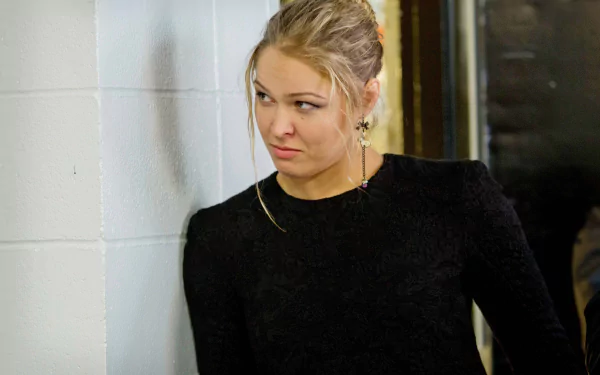 A high-definition desktop wallpaper featuring Ronda Rousey, showcasing her intense expression against a simple background, embodying the spirit of sports and determination.