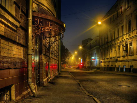 Nighttime street scene in Moscow, Russia, illuminated by warm streetlights along historic buildings and an empty road, captured in 4K Ultra HD detail.