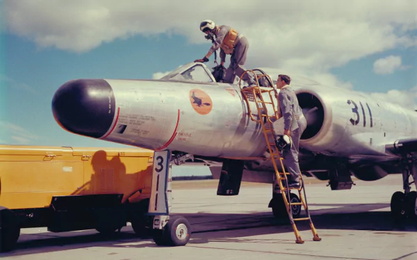8K Ultra HD PC desktop wallpaper and background: military aircraft — ground crew climbs a ladder into a vintage jet bomber on the tarmac beneath a blue sky.