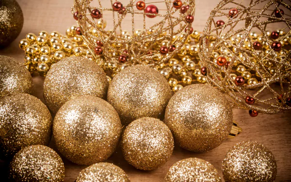 A 4K Ultra HD desktop wallpaper featuring shimmering gold Christmas ornaments and festive holiday decorations with intricate beadwork.