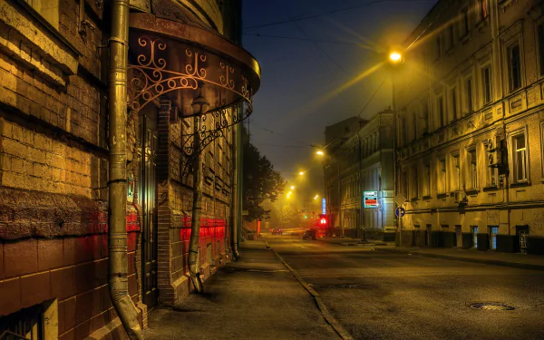 Nighttime street scene in Moscow, Russia, illuminated by warm streetlights along historic buildings and an empty road, captured in 4K Ultra HD detail.