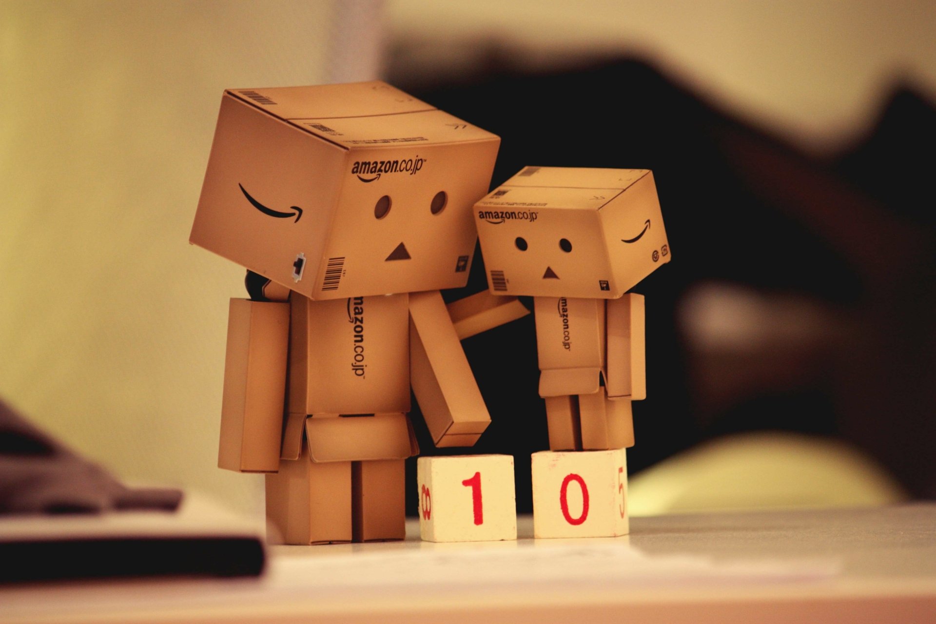 4K Ultra HD PC desktop wallpaper of two danbo cardboard figures beside blocks reading 1 and 0 against a warm bokeh background — Misc, danbo