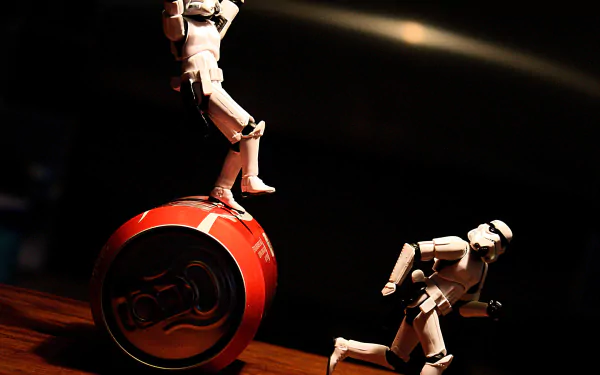 HD PC desktop wallpaper of Star Wars stormtrooper toy figurines in dramatic lighting — one balancing on a red yo-yo, another posed running; sci-fi themed background