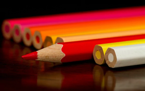 Close-up photo of colored pencils arranged in a row, with vibrant hues highlighted against a dark background, captured in sharp 4K Ultra HD quality.