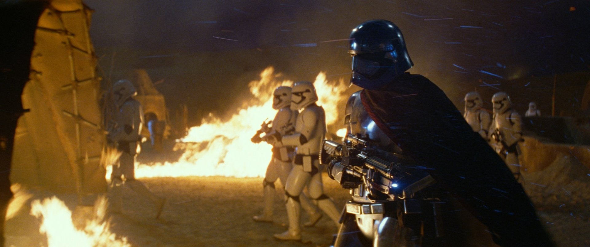Captain Phasma stands prominently in front of stormtroopers amidst a fiery backdrop, a striking scene from Star Wars Episode VII: The Force Awakens, captured in vivid HD detail.
