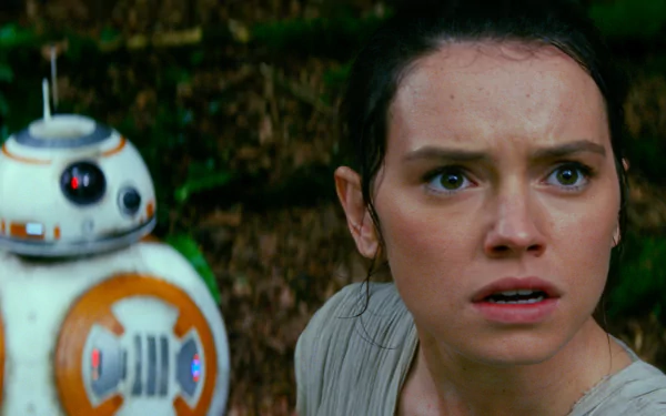 Daisy Ridley as Rey from Star Wars, alongside BB-8, displaying a moment of tension in Star Wars: Episode VII - The Force Awakens. HD desktop wallpaper featuring iconic characters.