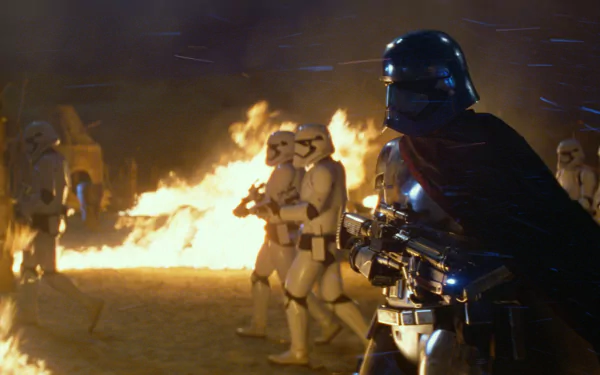 Captain Phasma stands prominently in front of stormtroopers amidst a fiery backdrop, a striking scene from Star Wars Episode VII: The Force Awakens, captured in vivid HD detail.
