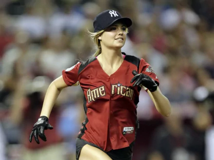 HD desktop wallpaper featuring celebrity Kate Upton wearing a baseball jersey and cap, captured in action during a game. A lively and dynamic image for sports fans.