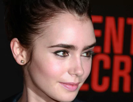 Close-up HD PC desktop wallpaper of an unknown female celebrity with dark brows, winged eyeliner and a soft smile against a red-black background.